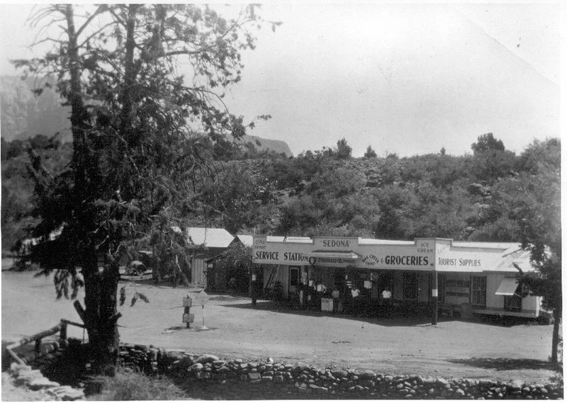 Historic black-and-white photograph of the Hart Store with its groceries and service-station signs