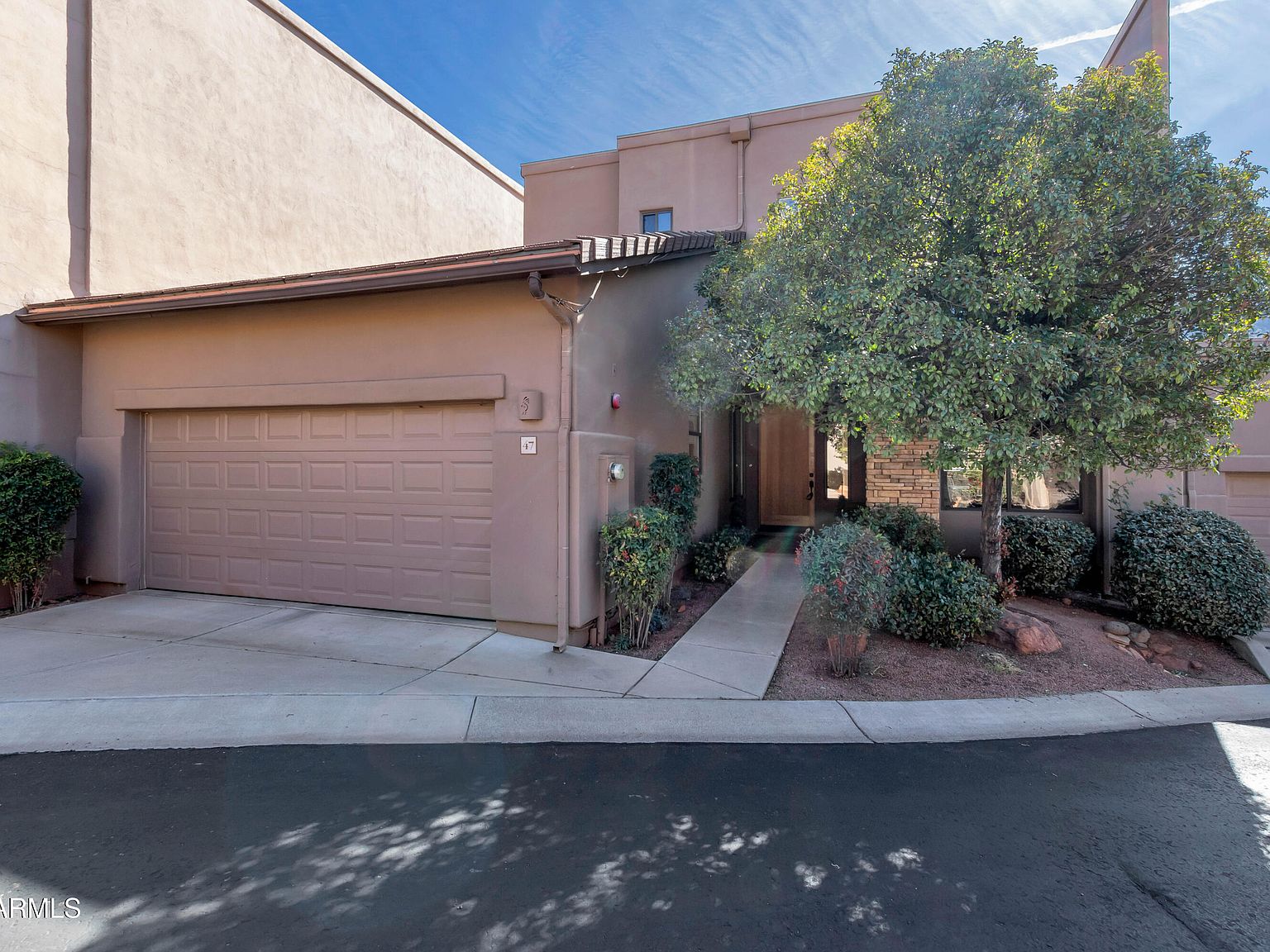 The front of Mesa Grande, with an attached garage and a walkway to the front door